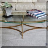 F10. Brass and glass oval coffee table. 15”h x 52”w x 26”d - $250 